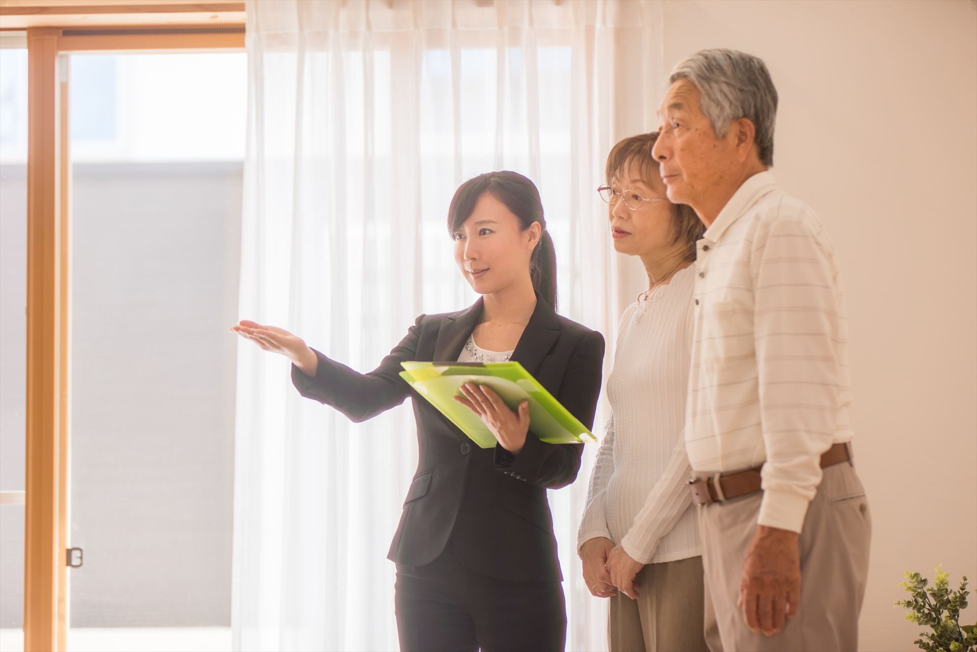 シニア夫婦に家の設備を説明するスタッフ